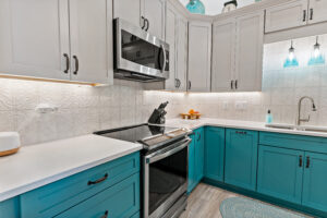 blue kitchen cabinets and stainless steel oven