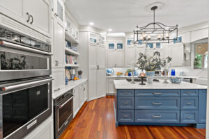 blue kitchen island with hardwood floors