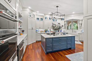 blue kitchen island with hardwood floors