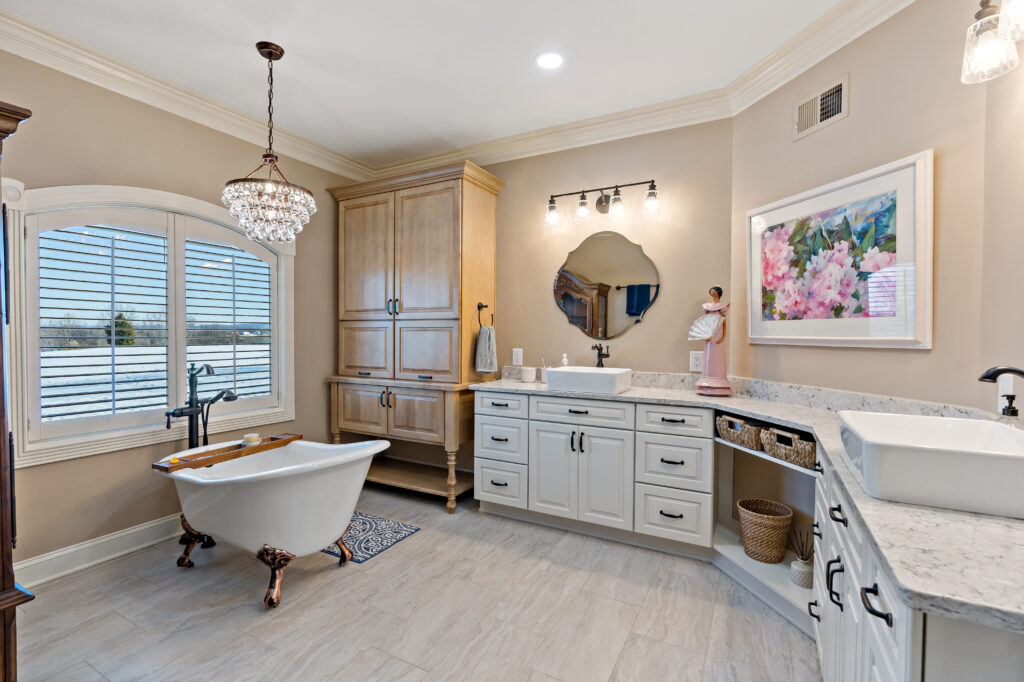 bathroom remodel with dual vanity sinks and soaking tub